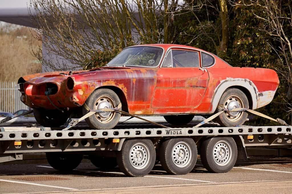 a car on a flatbed trailer doing a towing services in plano